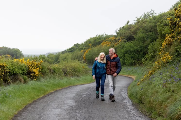 A man and woman walking down a country road in the UK