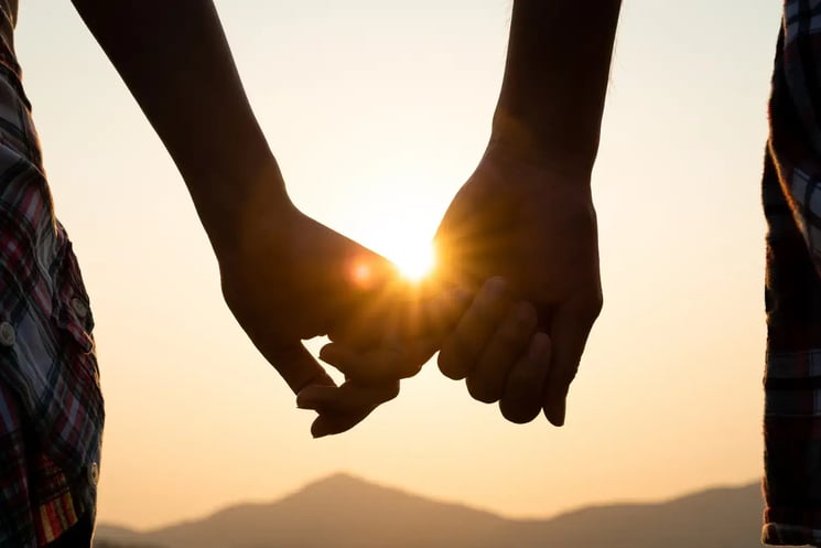 Someone holding hands at sunset