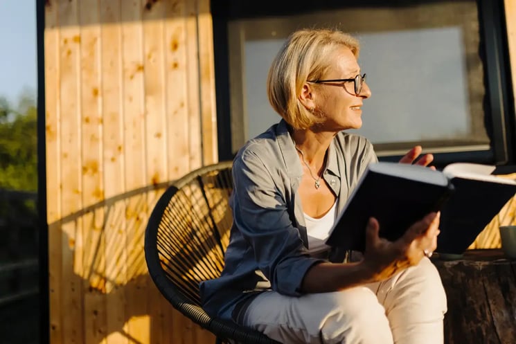 A woman sat outside with a book 