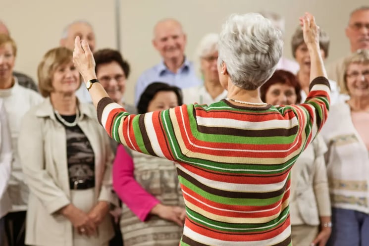 A choir of people being led by a choir conductor