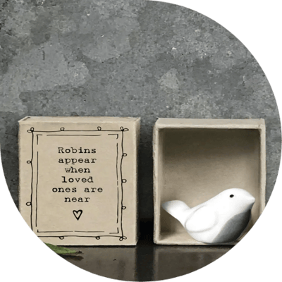 A small, white robin figure in a box
