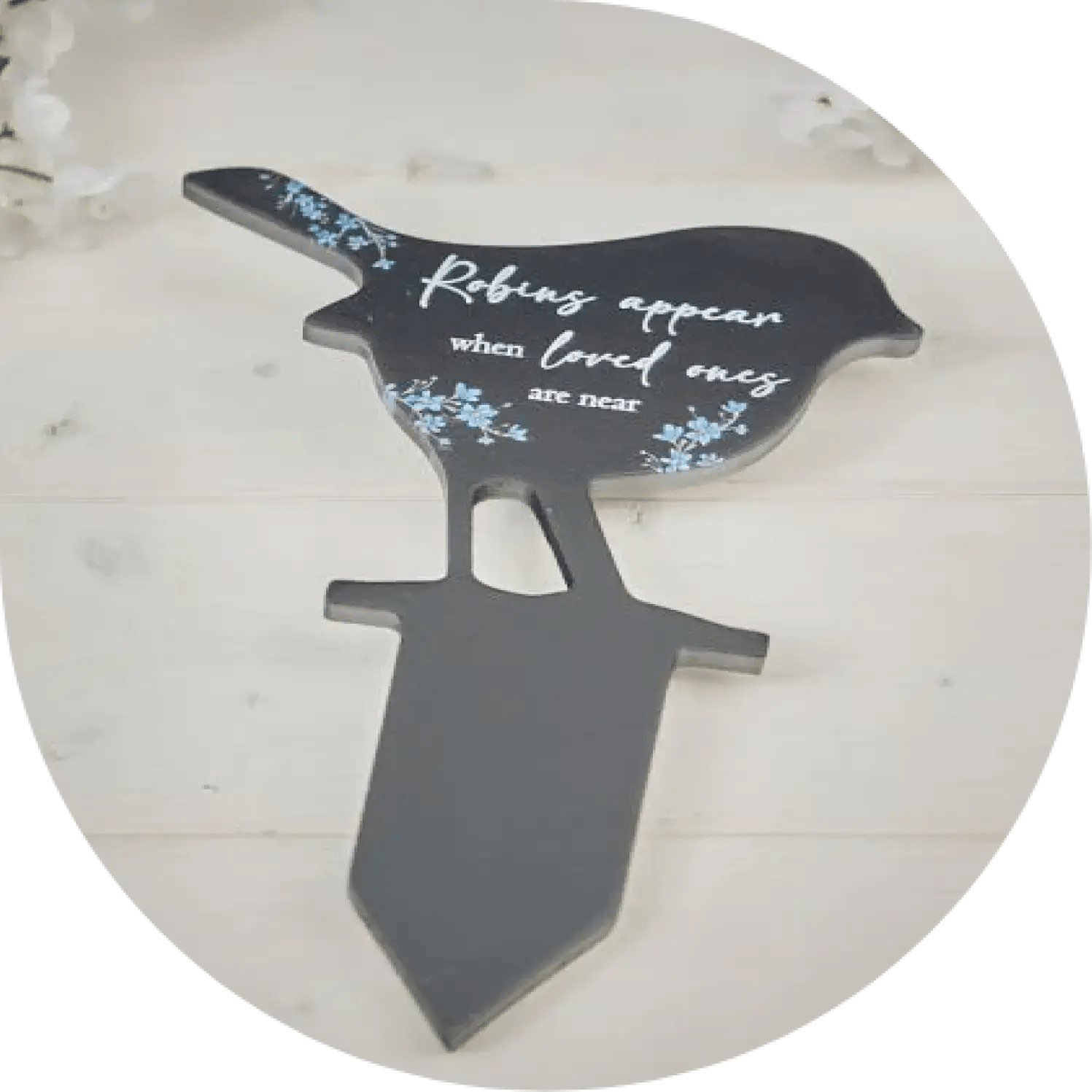 A black garden stake with a robin shape