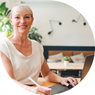 A woman using a laptop smiling at the camera