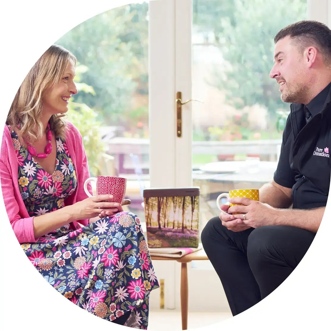 Ryan from Pure Cremation chatting with a lady over a cup of coffee.