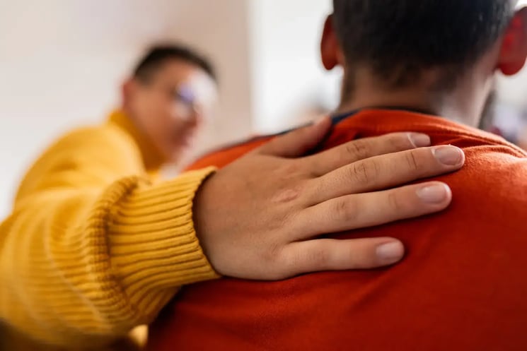 Someone with a hand on a person's shoulder
