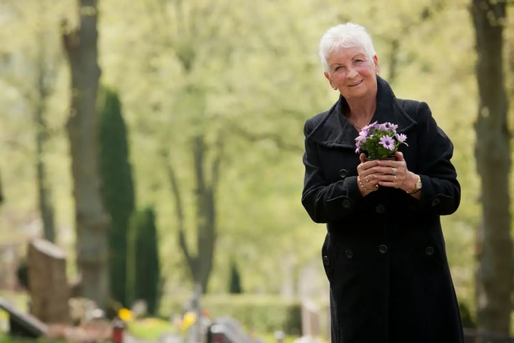 A woman carrying funeral flowers