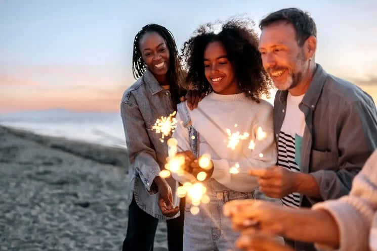 A family lighting sparklers on a beach