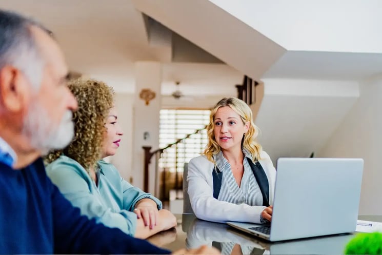 A woman talking to a man and woman in their home