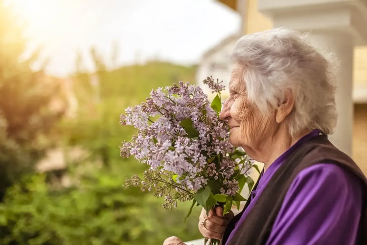 A woman smelling flowers at sunset