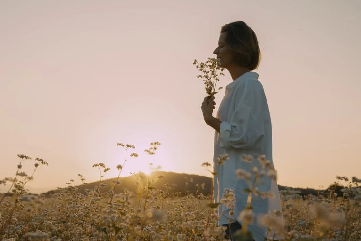 A woman in a field, holding flowers