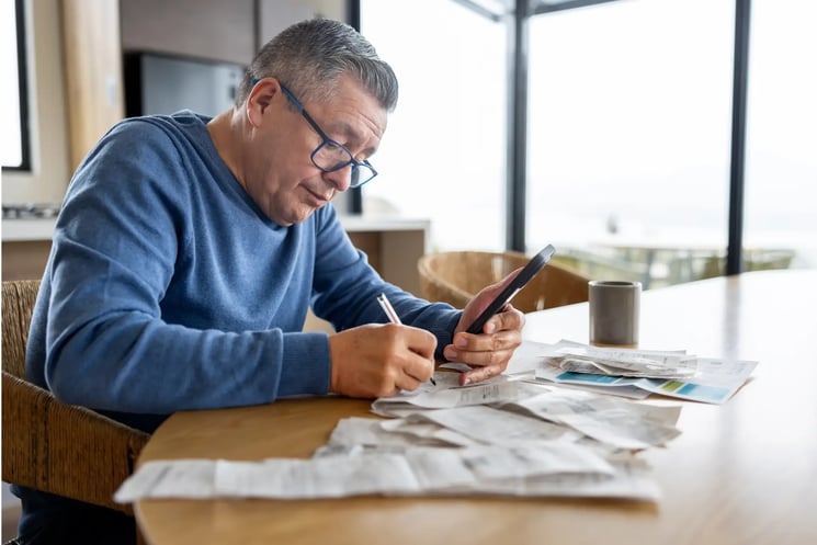 A man doing paperwork, using a calculator