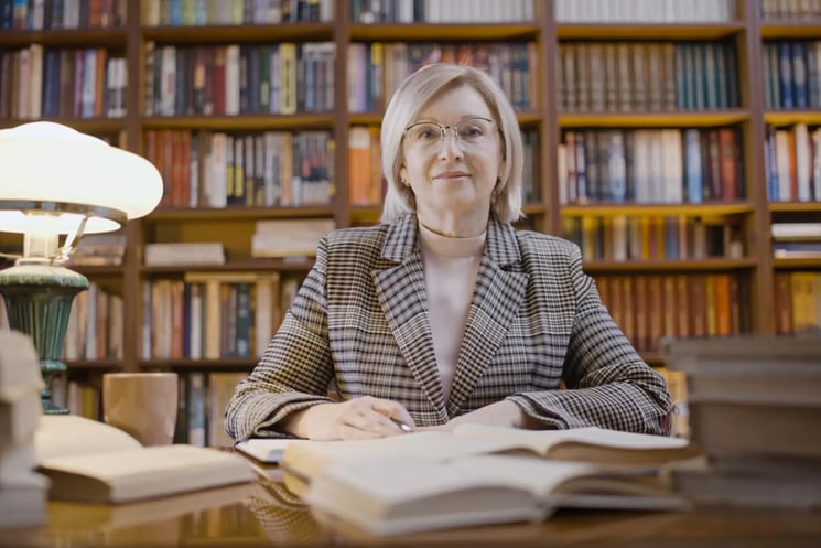 A woman in a library reading a book 