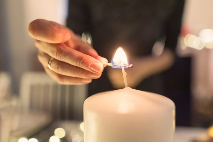 A hand lighting a candle